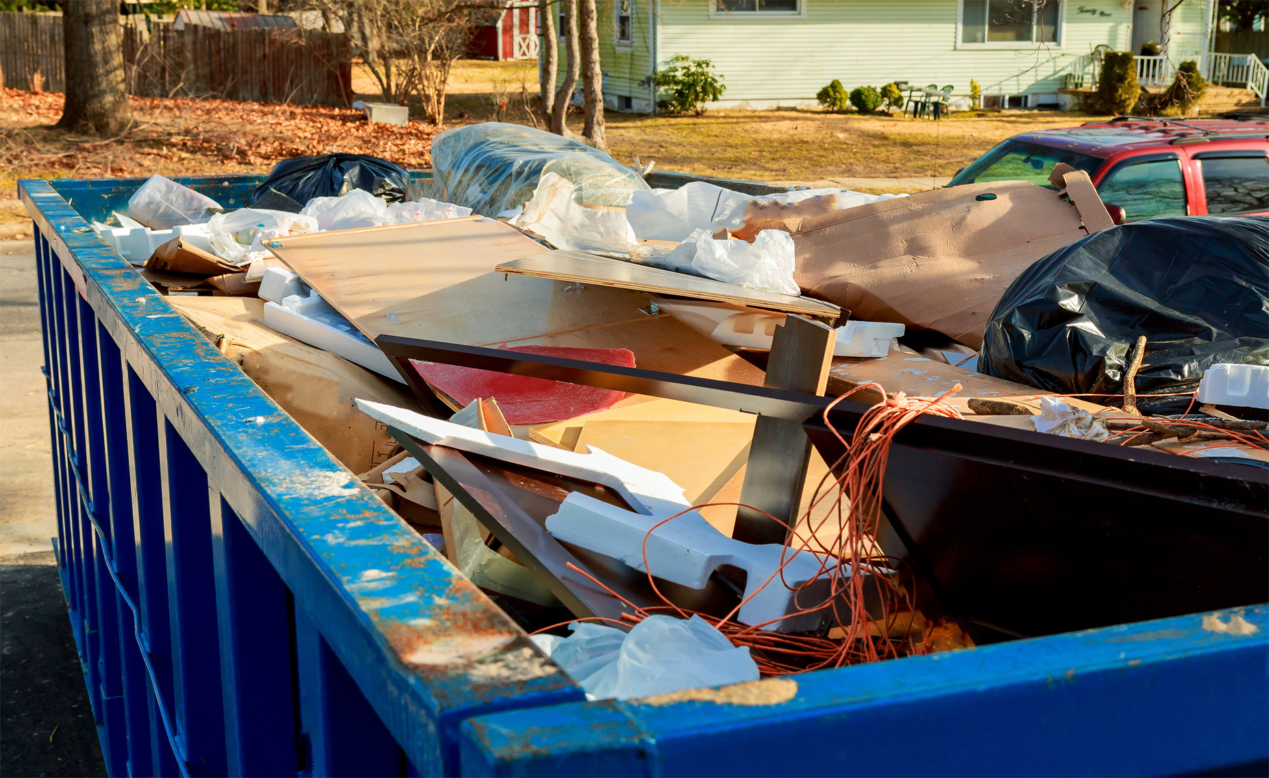 Blue dumpster full of junk